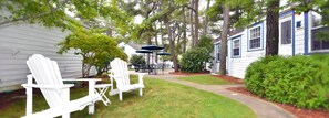 Relax in the serene backyard with a dining area and seating space under a shaded umbrella.