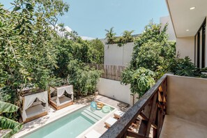 A pool area with two wooden beds and a small pool. - Villa Sorella (Tulum)
