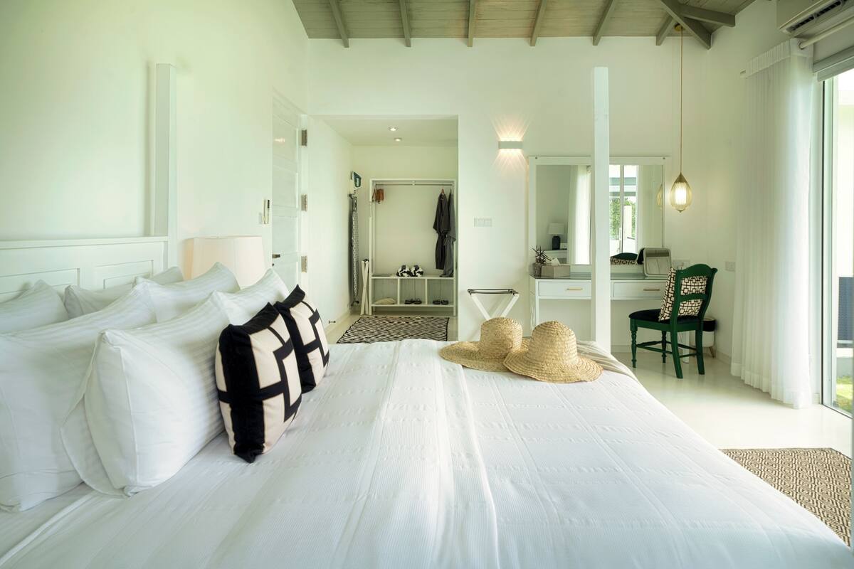 A spacious bedroom with a large bed, a desk, and a chair.