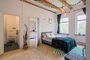 Une chambre à coucher avec un lit, une fenêtre avec des rideaux, un plafond en bois et une vue sur l’extérieur.