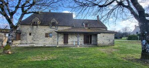 A stone house with a tiled roof, a small porch, and a grassy yard. - LA BASTIDE.... Beautiful typical Périgord noir house (Saint-Genies)