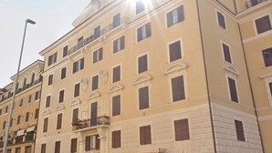 A multi-story building with a symmetrical facade, large windows, and balconies. - Peaceful Roman Retreat (Roma)