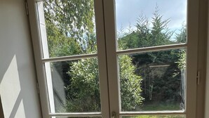 A room with a large window overlooking a garden.