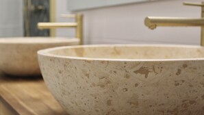 A bathroom with two beige ceramic sinks with gold fixtures. - Charming apartment near the sea (Cavalaire-sur-Mer)
