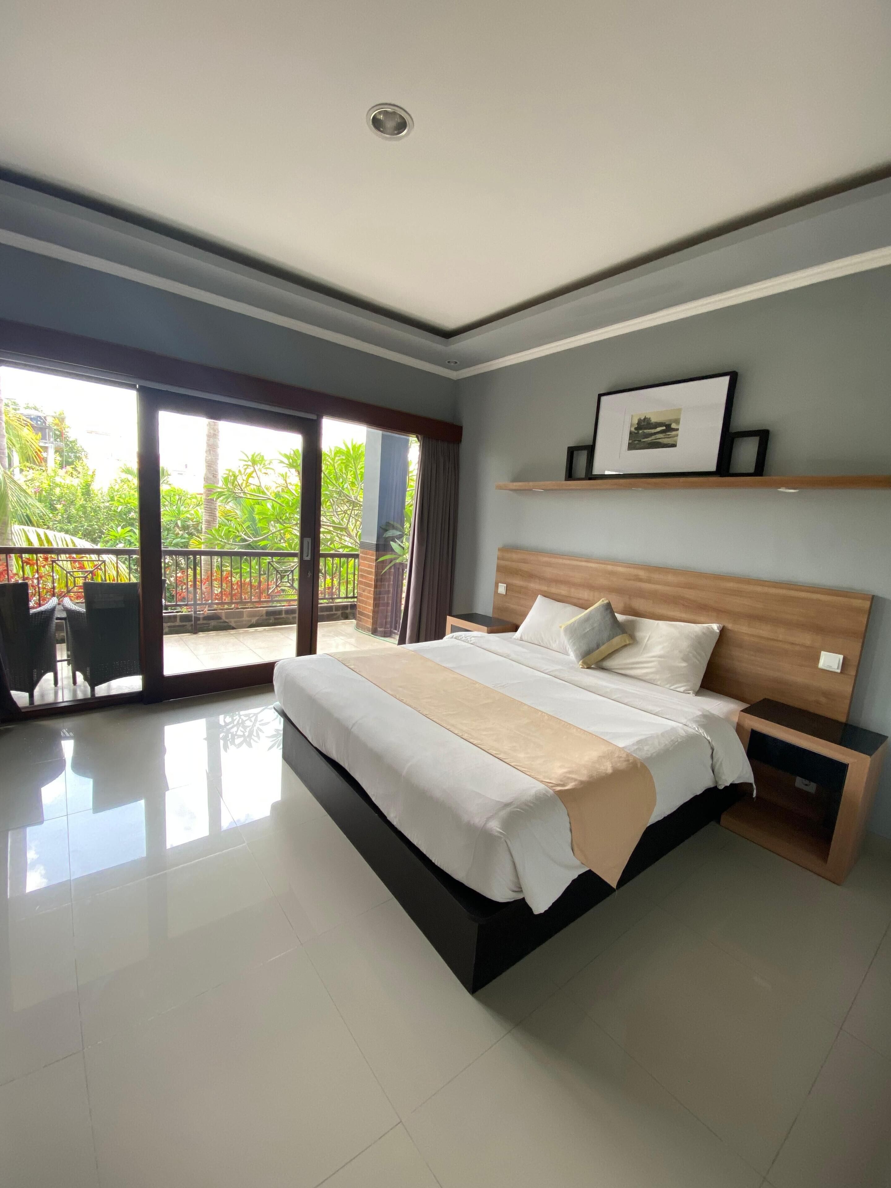 Un dormitorio moderno con una cama grande, una mesita de noche de madera y un cuadro enmarcado en la pared.