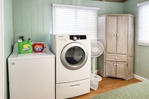 A laundry area with a washing machine, a dryer, and a cabinet. - Cranmore Retreat, Walk to Slopes, Hot Tub, Game Room, Dog-Friendly, Sleeps 16+ (Conway)