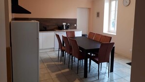A compact kitchen with a dining area, a built-in oven, and a window providing natural light. - Gîte du Château de Montriou - up to 12 people (Feneu)