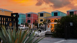 A row of colorful houses with a boat docked in front.