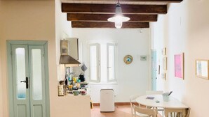 Une cuisine équipée d’une table et de chaises, d’un réfrigérateur et d’une fenêtre donnant sur un paysage agréable.