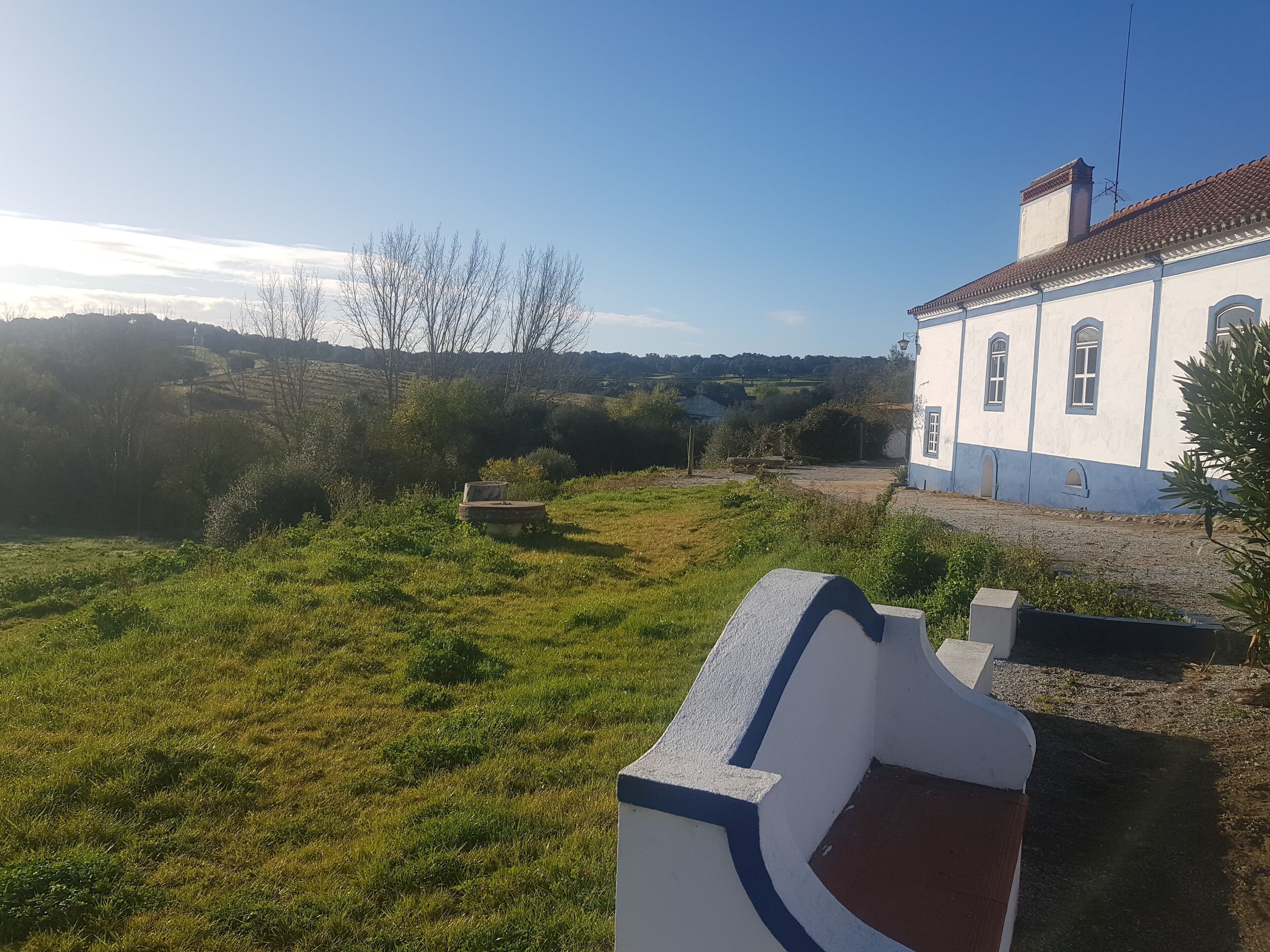 Un edificio blanco con detalles azules y tejado de tejas rojas.
