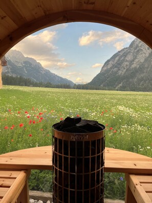 A wooden bench with a metal trash bin labeled "HARVIA" in front of a scenic mountain view. - Chalet Leutasch With Ski Trail & Mountain Views (Leutasch)