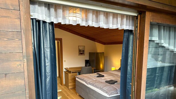A bedroom with a bed, a desk, and a chair. - Alpine Hideaway in Saalfelden (Saalfelden am Steinernen Meer)