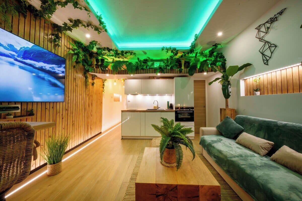 Ein modernes Wohnzimmer mit Fernseher, Sofa und Küchenzeile.