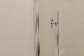 Een douche,  milieuvriendelijk toiletgerief, een haardroger, een bidet