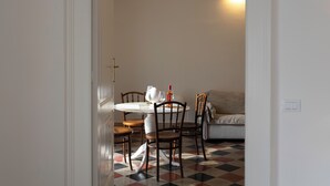 Un coin repas avec une table ronde, des chaises en bois et un sol à motifs.
