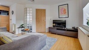 A modern living room with a sofa, TV, and a dining area with a small table and chairs. - Quaint 1 Bedroom 1st Floor Flat (Doncaster)