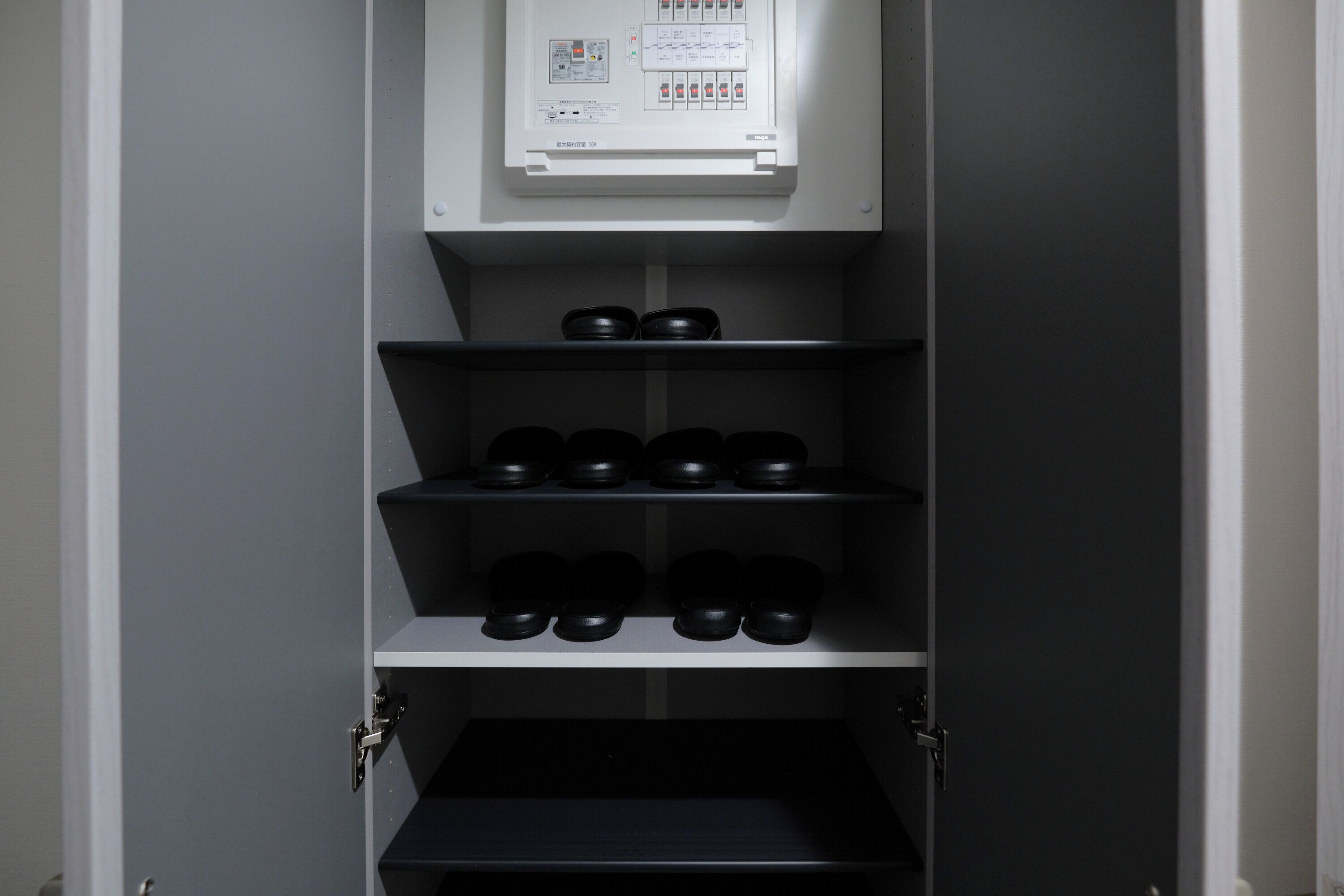 A storage cabinet with multiple shelves, each containing black containers.