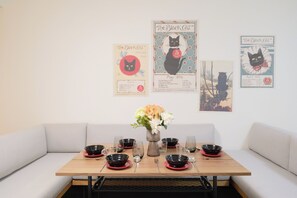 A dining table with black and red plates, glasses, and a vase of flowers. - Mugenzaka by Tranova (Tokyo)