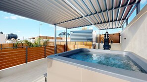Une terrasse sur le toit dotée d’un jacuzzi, d’une plateforme en bois et d’un espace couvert offrant une vue sur le panorama urbain.