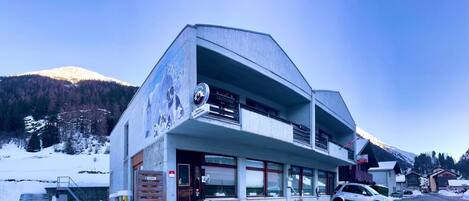 Un edificio moderno con techo inclinado, ventanas grandes y un letrero que indica que es un restaurante.