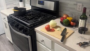Une cuisine moderne équipée d’une cuisinière, d’un four à micro-ondes et de divers ustensiles de cuisine.