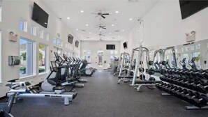 A gym with treadmills, weight machines, and dumbbells.