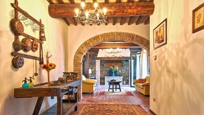 A cozy interior with a rustic wooden bench, a patterned rug, and a stone fireplace. - Podere La Marroneta (Tuscany Hills & private Pool) (Rivalto)