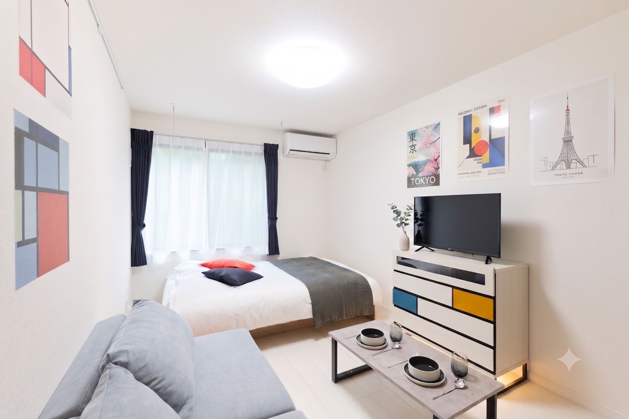 Ein modernes Hotelzimmer mit einem Bett, einer Couch, einem Fernseher und einem Essbereich.