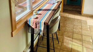 Una cocina con una mesa de madera, una ventana y una puerta.
