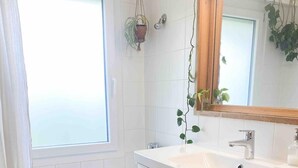 Un baño moderno con bañera, un lavabo grande y un espejo.