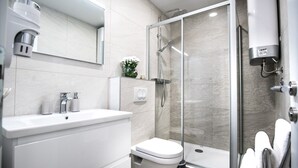 A modern bathroom with a glass shower enclosure, a white sink, and a toilet. - Spectrum Deluxe Rooms Dubrovnik (Dubrovnik)