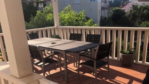 A covered patio with a table and chairs, surrounded by a white railing. - Spectrum Deluxe Rooms Dubrovnik (Dubrovnik)
