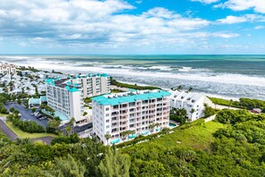 A coastal hotel with multiple buildings, a parking lot, and a view of the ocean. - LUXURY 4-Ensuites Beach condo in Jupiter 100 Yards to Ocean!Ocean Views! (Jupiter)