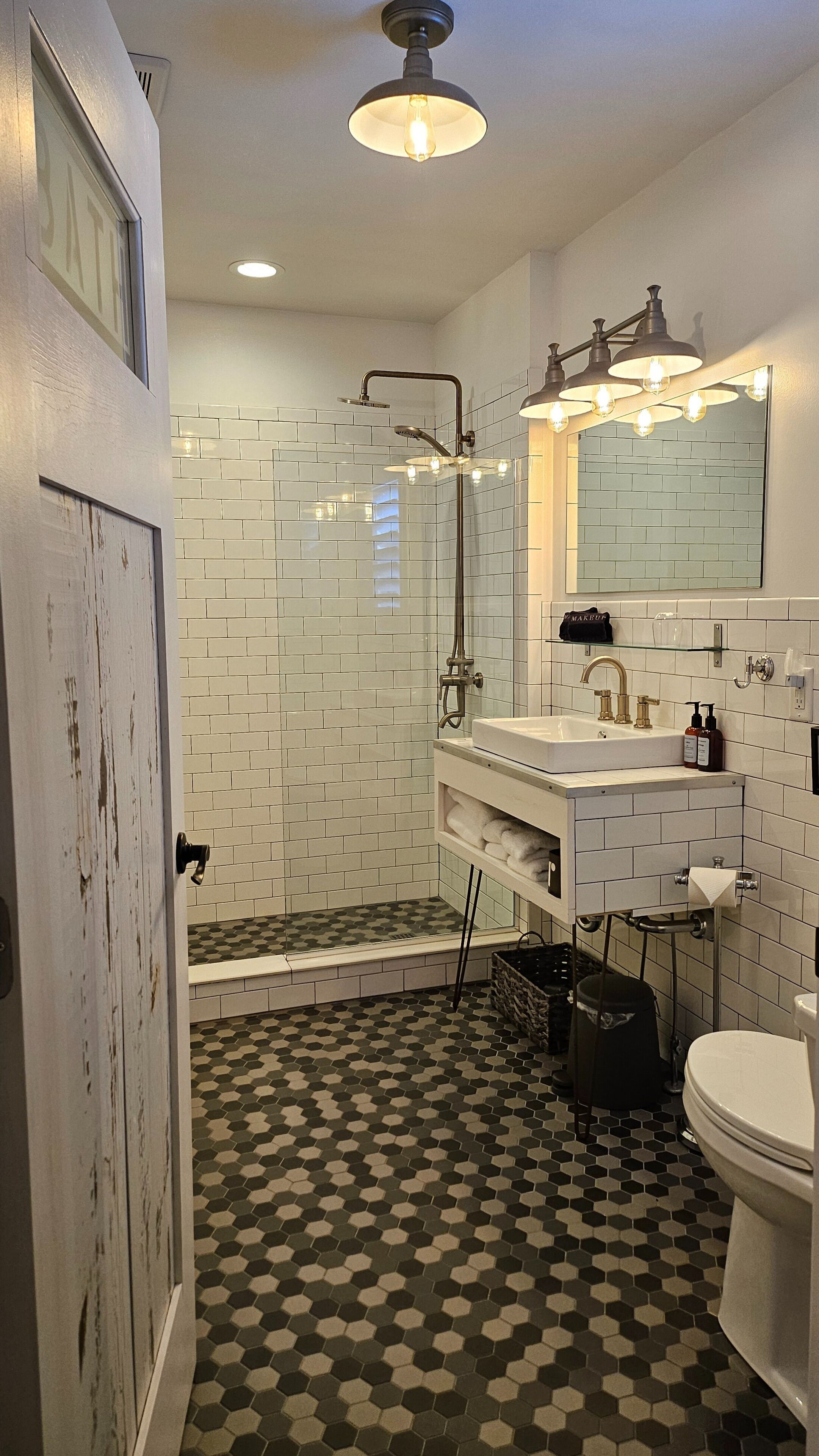 A bathroom with a shower, sink, and toilet.
