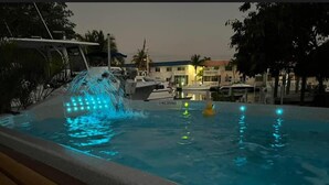A swimming pool with a waterfall feature and a yellow rubber duck. - Charming 2-bedroom house in beautiful Marathon with Swim Spa, Dock, Pets Welcome (Marathon)