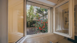 Eine Küche mit Fensterblick auf einen Garten mit roten Blumen.