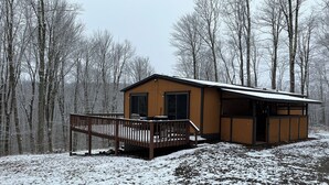 A cabin with a deck, surrounded by a forest. - Private Serene Cabin (Coudersport)