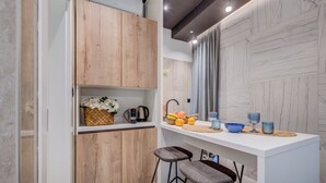 Une cuisine moderne avec des meubles en bois, un plan de travail blanc et des tabourets de bar.