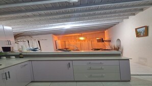 Een moderne keuken met witte kasten, een aanrecht en een ingebouwde oven.