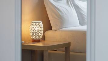 A room with a bed, a nightstand, and a wall-mounted picture.