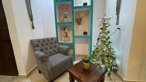 A living room with a grey sofa, a wooden coffee table, and a decorative Christmas tree. - Central Hacienda 5 min from the beach and the famous 5th ave with swimming pool (Playa del Carmen)