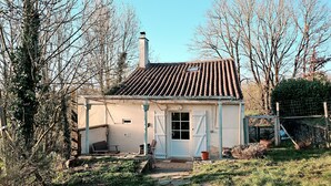 A small, single-story house with a tiled roof, a front door, and a small porch area.