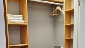 Ein begehbarer Kleiderschrank mit mehreren Holzböden und einer Kleiderstange.