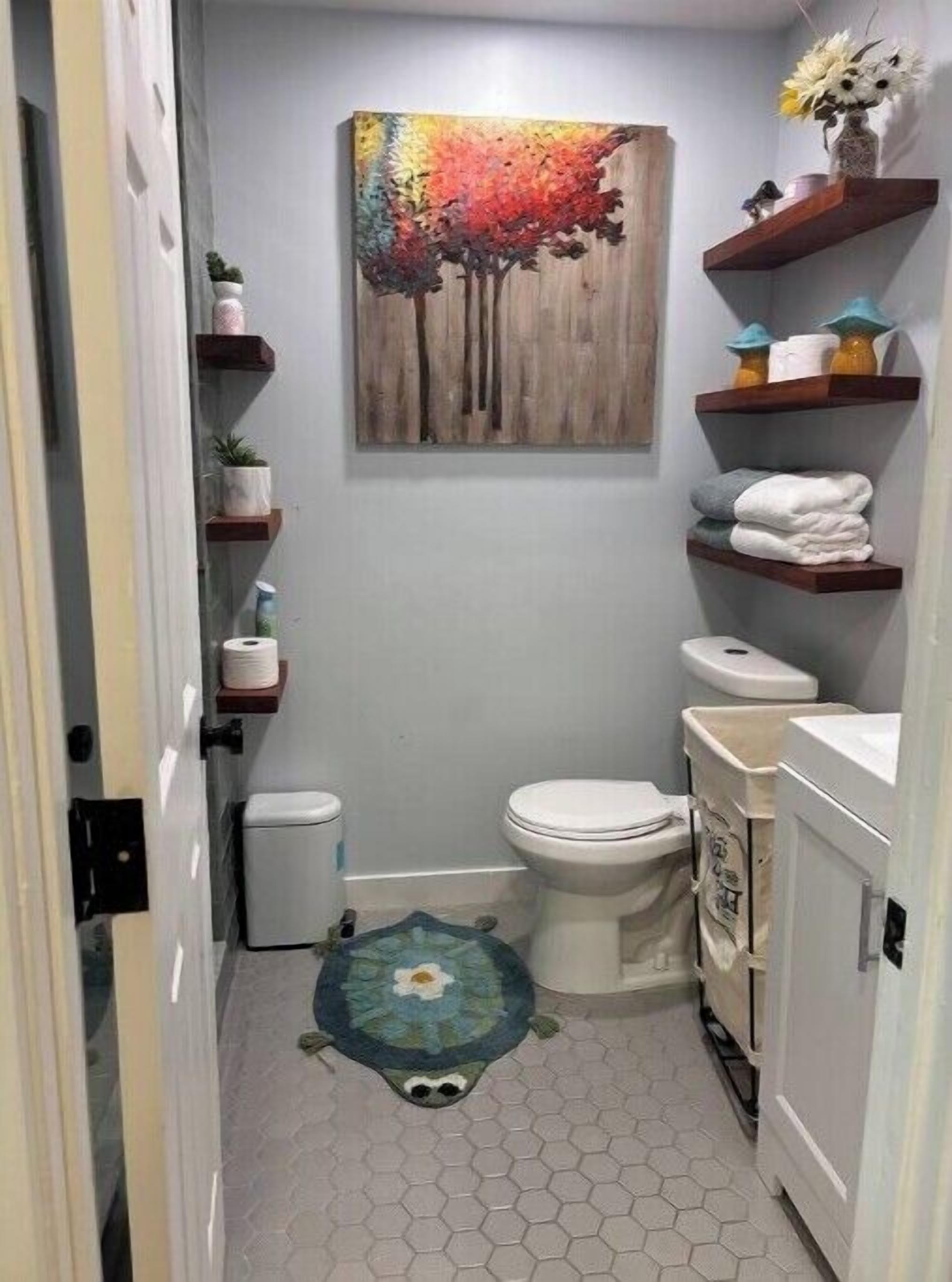 A compact bathroom with a toilet, sink, and shelves with toiletries.