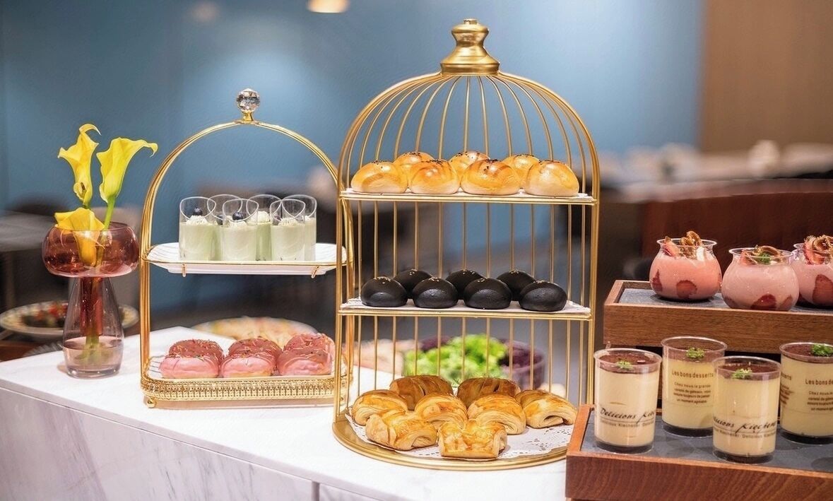 A buffet with various pastries, desserts, and beverages.