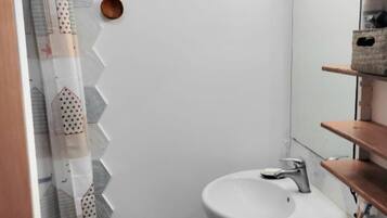 Een douche, handdoeken, zeep, shampoo