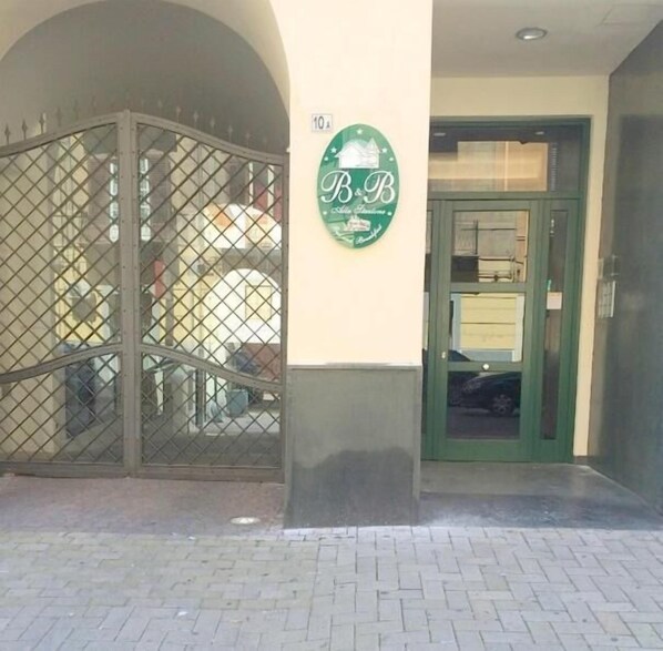 A gated entrance with a sign reading "B&B" and a green door. - B&B Alla Stazione (Palermo)
