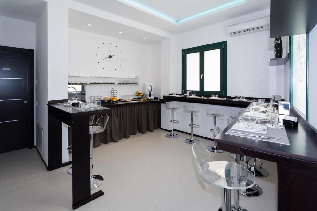 A modern kitchen with a dining area, featuring a bar counter, bar stools, and a large window.