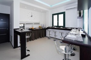 Una cocina moderna con comedor, que incluye una barra y taburetes, además de un amplio ventanal.