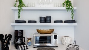 A kitchen with white shelves, a toaster oven, a coffee maker, and a bowl on the counter. - Modern & Spacious Retreat in Hato Rey | Unit 2 (San Juan)